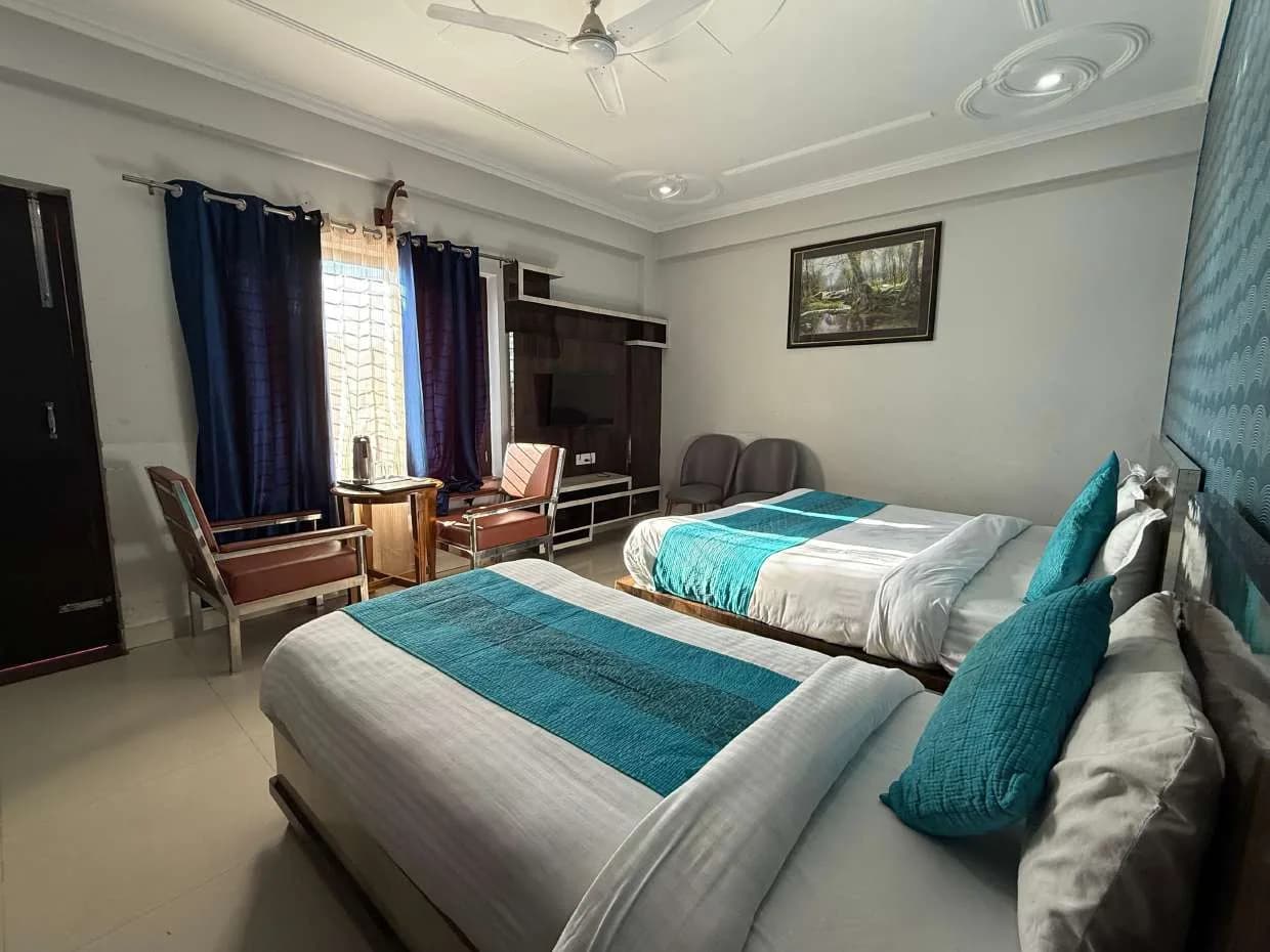 Room with two beds and a window seating corner