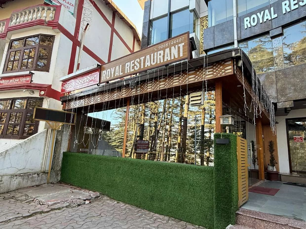 Entrance of Royal Restaurant with wooden canopy and green boundary